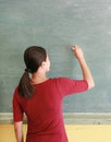 Asian teacher writing on blackboard with chalk in classroom, Educations concept Royalty Free Stock Photo