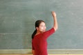 Asian teacher writing on blackboard with chalk in classroom, Educations concept Royalty Free Stock Photo
