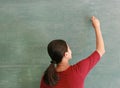 Asian teacher writing on blackboard with chalk in classroom, Educations concept