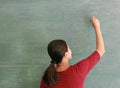 Asian teacher writing on blackboard with chalk in classroom, Educations concept Royalty Free Stock Photo