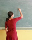 Asian teacher writing on blackboard with chalk in classroom, Educations concept Royalty Free Stock Photo
