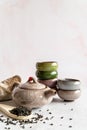 Asian teapot with two piles of colorful teacups and pack of tea on white marble background