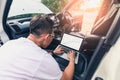 The asian technician analyze the car`s engine graph on laptop computer in the garage. the concept of automotive, repairing, mechan Royalty Free Stock Photo