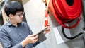 Asian technician checking fire hose reel Royalty Free Stock Photo