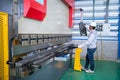 Asian technician worker wearing a safety suit Setting Hydraulic Press Break Machine and Prepared Sheet Metal Shearing in Royalty Free Stock Photo