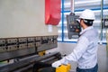 Asian technician worker wearing a safety suit Setting Hydraulic Press Break Machine and Prepared Sheet Metal Shearing in Royalty Free Stock Photo