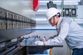 Asian technician worker wearing a safety suit and sheet Metal Bending in industrial factory, Safety first concept Royalty Free Stock Photo