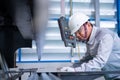 Asian technician worker wearing a safety suit and sheet Metal Bending in industrial factory, Safety first concept Royalty Free Stock Photo