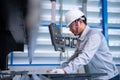 Asian technician worker wearing a safety suit and sheet Metal Bending in industrial factory, Safety first concept Royalty Free Stock Photo