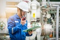 Asian technician working with the walkie-talkie and checklist