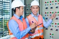 Asian technicians at panel on construction site