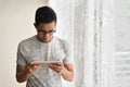 Asian teen buzy with his tablet in his home Royalty Free Stock Photo