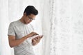 Asian teen buzy with his tablet in his home Royalty Free Stock Photo