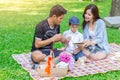 Asian teen family teaching son homework while picnic Royalty Free Stock Photo