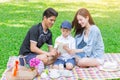 Asian teen family teaching son while picnic in the park Royalty Free Stock Photo