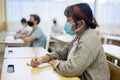 Asian teen girl in protective mask studying in college