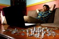 Asian Teen relaxing in front of laptop computer and a stack of coins Royalty Free Stock Photo