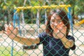 Asian teen smile hand catch welded wire fence