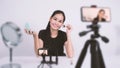 Asijský žena sedět před kamerou a žít vysílání 