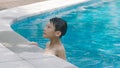 Asian teenage boy swimming outdoors in blue pool in summer Royalty Free Stock Photo