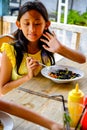 Asian Teenage Girl Having Healthy Charcoal Pasta Lunch at a Restaurant