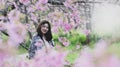 Asian teenage girl travels happily taking pictures with cherry blossoms