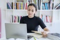 Asian teenage girl using a laptop in library Royalty Free Stock Photo