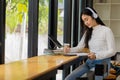 Asian teenage girl wearing headphones studying online with internet chatting teacher exam preparation white girl student learning Royalty Free Stock Photo
