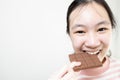 Asian teenage lady girl eating tasty chocolate bar,deliciously sweet,enjoy the natural taste,happy young woman holding chocolate Royalty Free Stock Photo