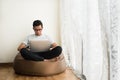 Asian teenage using laptop while relaxing