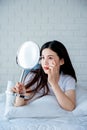 Asian teenage woman  looking at mirror and squeeze acne problem Royalty Free Stock Photo