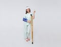 Asian teenage woman wearing a patient gown put on a cast Use a crutch to walk and Bandaged head due to accidental injury standing