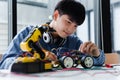 Asian teenager doing robot project in science classroom