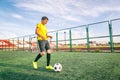 Asian teenager on a football field with a ball, sports and enter