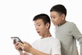 Asian teenager and his brother seeing the surprise on his tablet