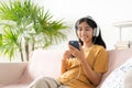 Asian teenager listen to music on smartphone with headphone enjoy. Asia woman using mobile phone happy smile  relax at home Royalty Free Stock Photo