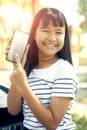 Asian teenager show white screen of smart phone screen and toothy smiling face happiness emotion Royalty Free Stock Photo