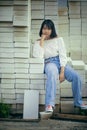 Asian teenager sitting on stack of contruction brick