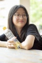 Asian teenager smiling face holding pastic bottle in hand Royalty Free Stock Photo