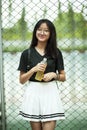 Asian teenager smiling face holding pastic bottle in hand Royalty Free Stock Photo