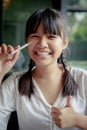 Asian teenager toothy smiling and holding body thermometer in hand