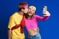 Asian teenagers kissing while taking selfie photo on cellphone