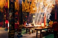 Asian Temple with beautiful sun rays shining through the ceiling lighting up the incense smoke. People praying in the Thien Hau