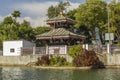 A Asian temple pagoda with green trees on the background of water Royalty Free Stock Photo