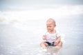 Asian ten month baby girl sitting and crying on the beach, worrying mother will leave her alone. Baby worries playing the beach