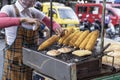 asian Thai fast food. Elderly masked woman roasting corn on phuket street