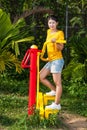 Asian Thai Girl with Exercise Machine in Public Park