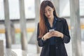 Asian Thai girl using mobile phone in business market.Person front view of Young Woman holding smartphone via internet to sending Royalty Free Stock Photo