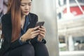 Asian Thai girl using mobile phone in business market.Person front view of Young Woman holding smartphone via internet to sending Royalty Free Stock Photo