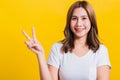 Woman teen smile standing wear t-shirt showing finger making v-sign symbol near eye Royalty Free Stock Photo